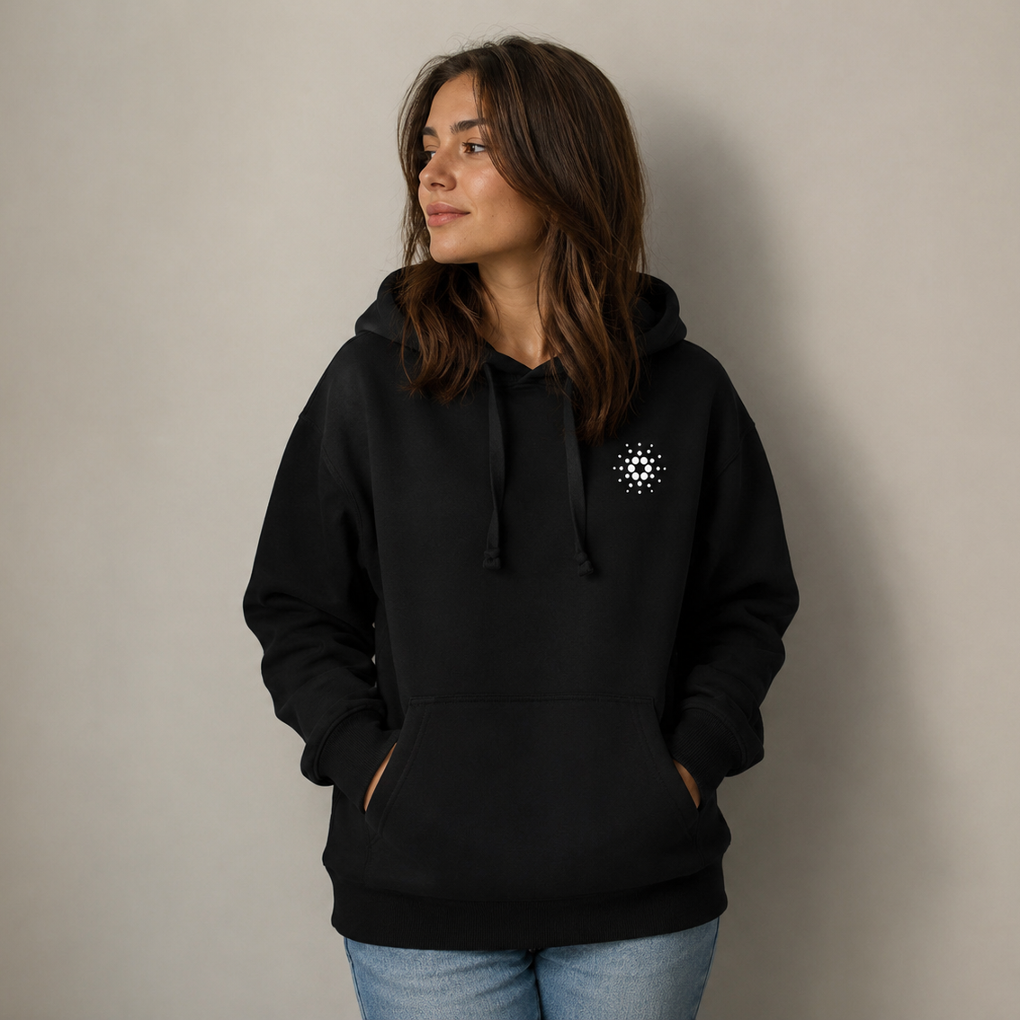 Person wearing a black hoodie with a Cardano logo on the front right side against a plain background