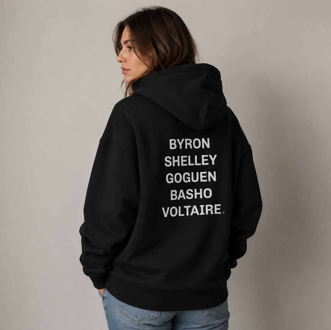 A woman wearing a black hoodie listing the different Cardano eras on the back of her hoodie.